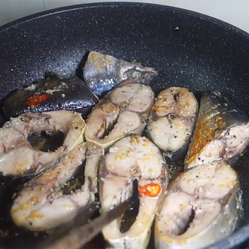Cá cam đã ướp được chiên sơ qua trên chảo để thịt cá săn chắc, không bị nát khi nấu nước dùng bún cá cam