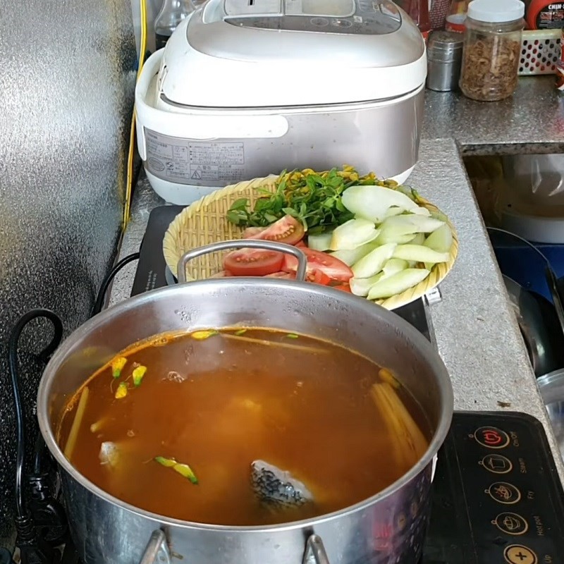 Các khúc cá chẽm đang dần chín trong nước canh chua