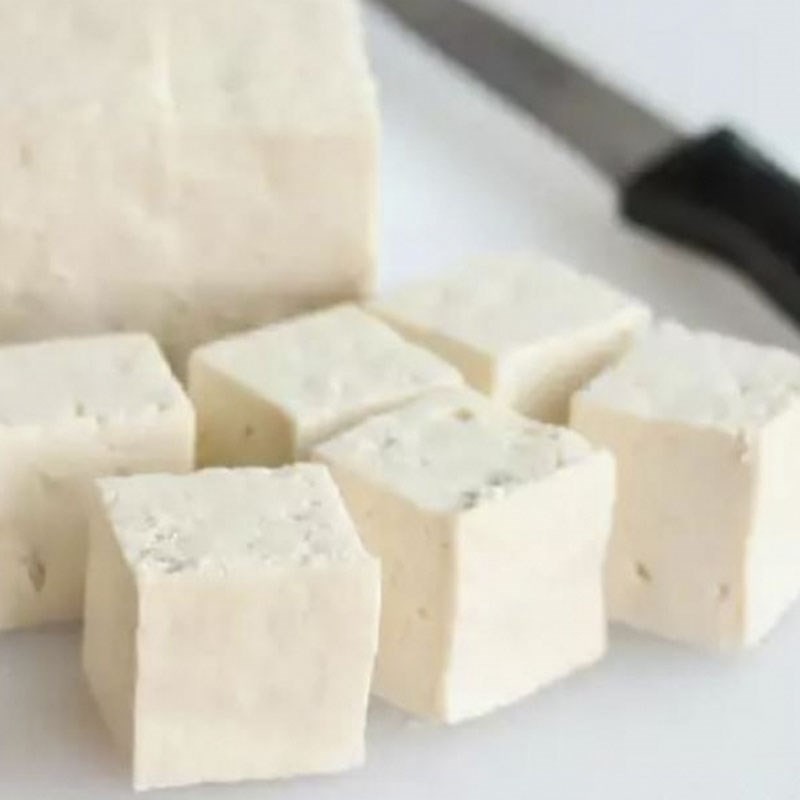 Đậu hũ trắng đang được chiên vàng đều trong chảo dầu nóng, tạo lớp vỏ giòn bên ngoài và giữ độ mềm bên trong