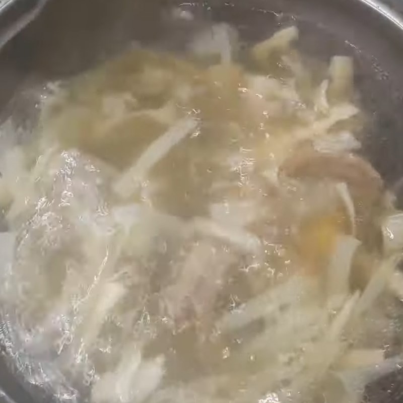 Thêm măng chua đã xào vào nồi nước dùng ngan đang sôi, đun thêm để các hương vị hòa quyện, tạo nên món bún ngan đậm đà