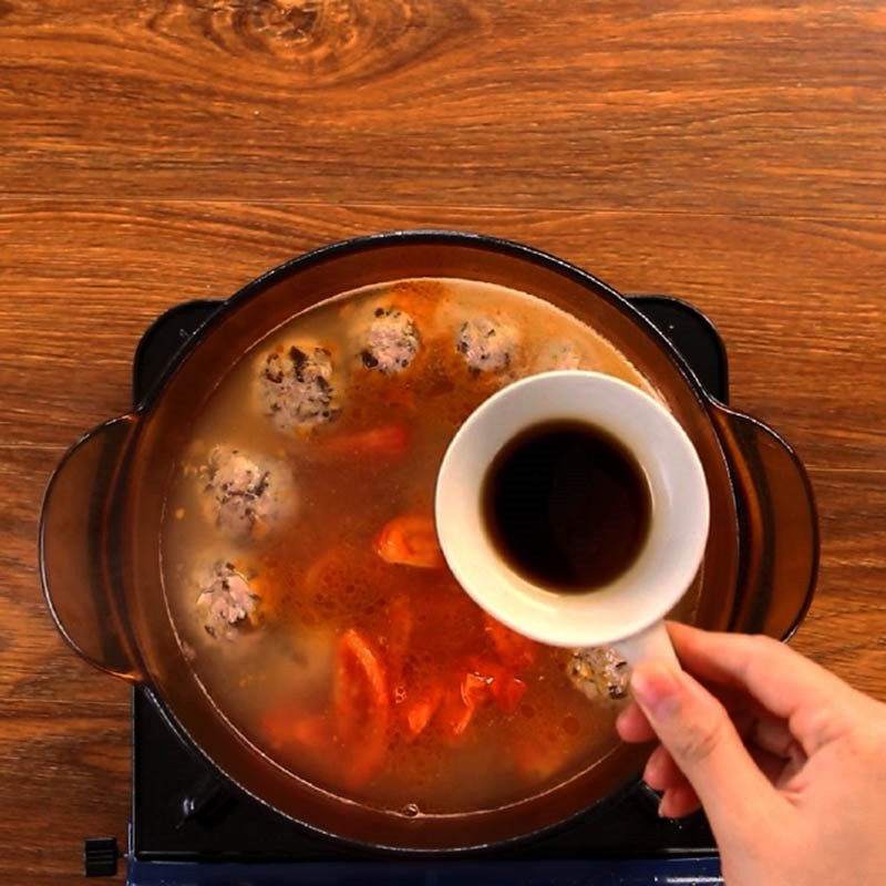 Nước dùng bún bung đang sôi sục, thơm lừng với sườn, mọc và cà chua đã xào, chuẩn bị nêm nếm
