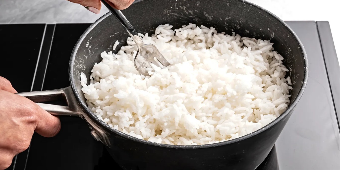 Đảo cơm để cơm tơi xốp sau khi nấu bằng bếp điện