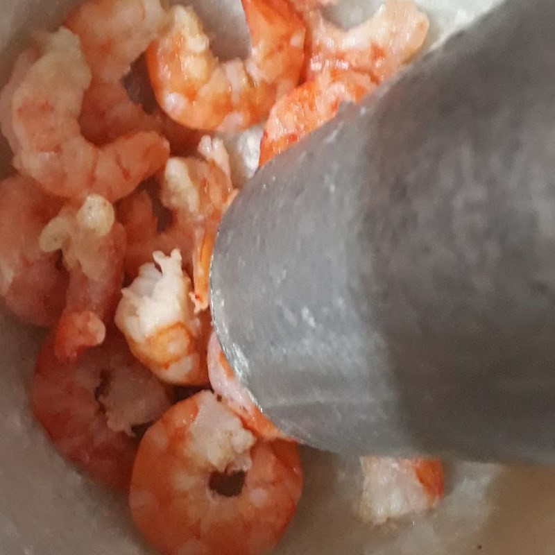 Tôm khô đã ngâm mềm được cho vào cối, chuẩn bị giã dập để tăng hương vị cho món canh cải ngọt tôm khô.