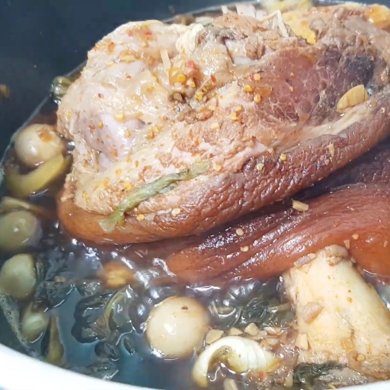 Nồi giò heo hầm dưa cải chua cà pháo đang sôi nhẹ