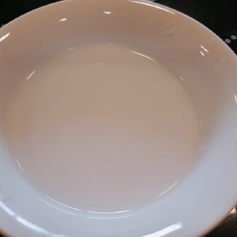 Thêm đường và bột vani vào nồi chè đậu đỏ đậu xanh đang sôi, điều chỉnh hương vị cho món ăn