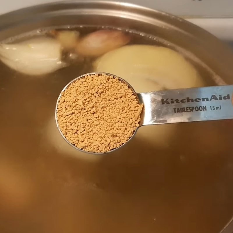 Nước dùng bánh canh cua giò heo đang sôi và vớt bọt