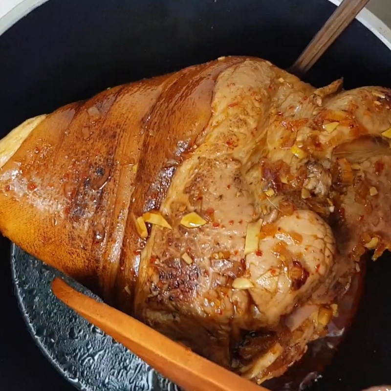 Giò heo đang được hầm sơ trong nước sốt trên bếp
