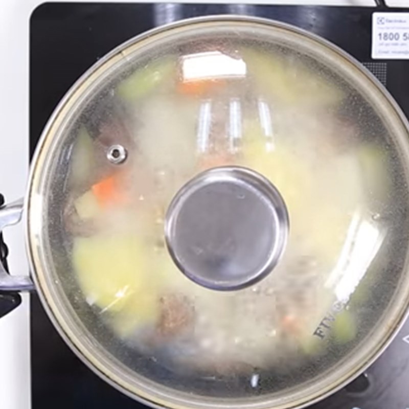 Hình ảnh món gân bò hầm khoai tây cà rốt đang sôi nhẹ trong nồi