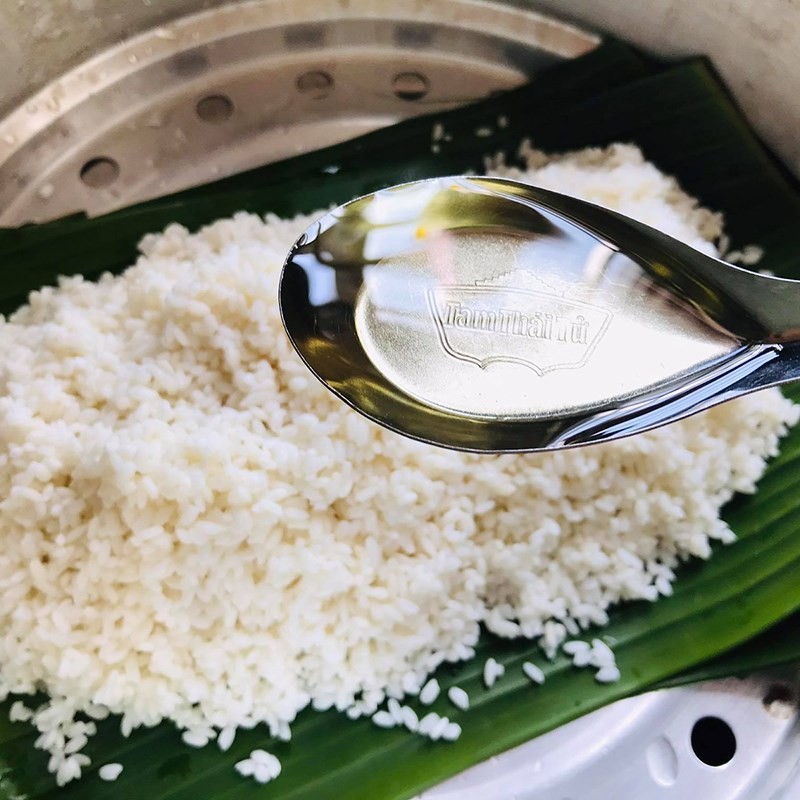 Rải lá dứa lên mặt nếp trong xửng hấp để xôi nếp ngon có hương thơm tự nhiên