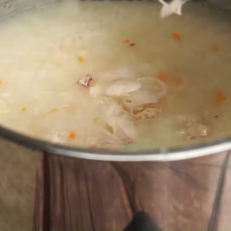 Cháo gà hạt sen với hạt sen, cà rốt và thịt gà đã được nêm nếm gia vị vừa ăn, sẵn sàng để múc ra tô.