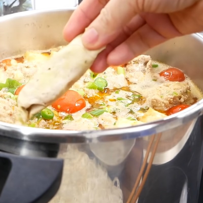 Hoàn thiện nồi bún riêu cua hộp với các nguyên liệu đã chín