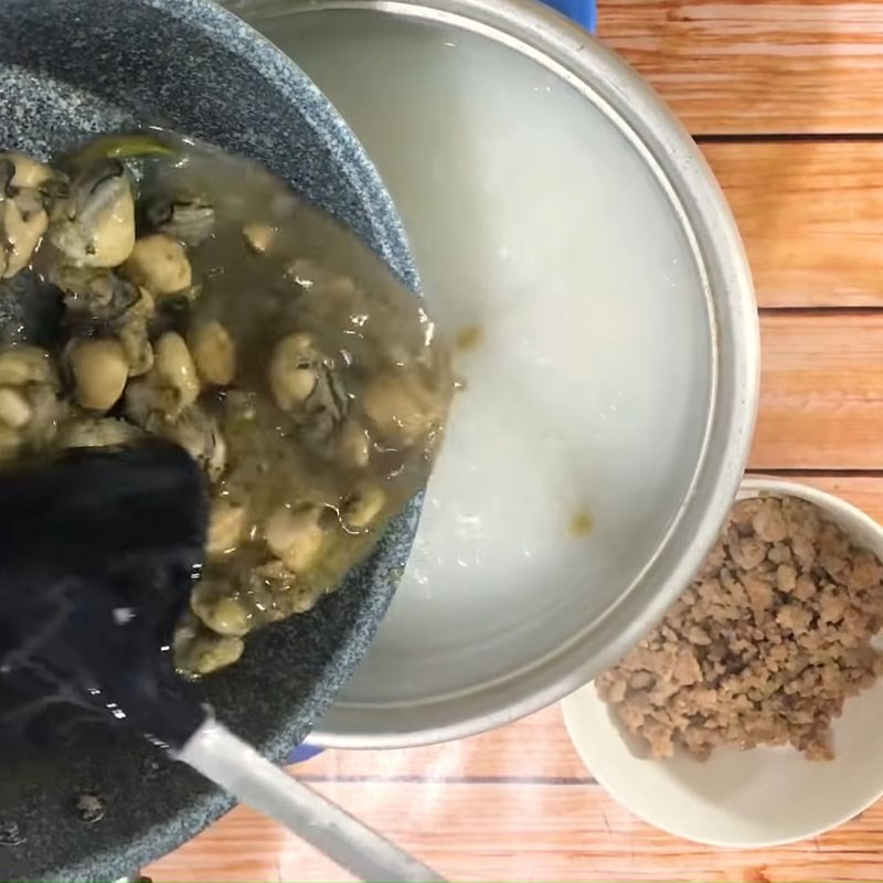 Thêm thịt băm và hàu đã xào vào nồi cháo đậu xanh đang sôi