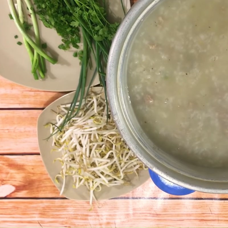 Khuấy đều cháo hàu đậu xanh thịt băm để các nguyên liệu hòa quyện và chín đều