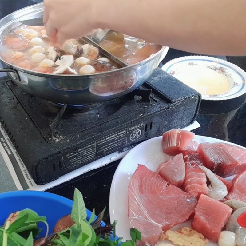 Thả cá ngừ, tôm và rau vào nồi lẩu cá ngừ đại dương