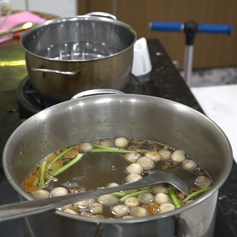 Cho nấm rơm vào nồi nước lèo bánh canh cá lóc đang sôi