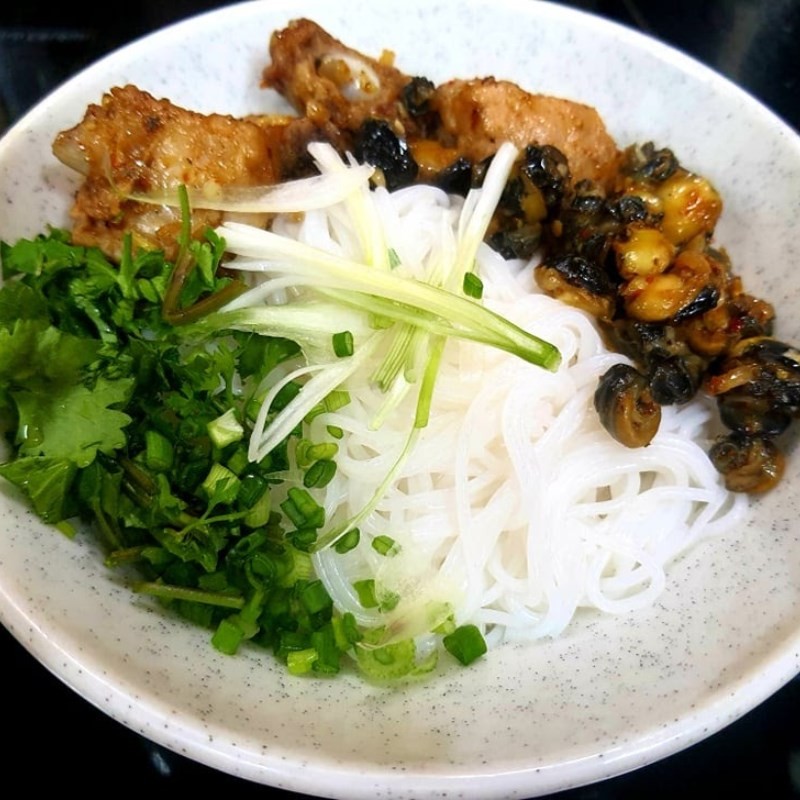 Bày bún tươi và topping ốc, sườn vào tô để hoàn thiện món bún ốc sườn