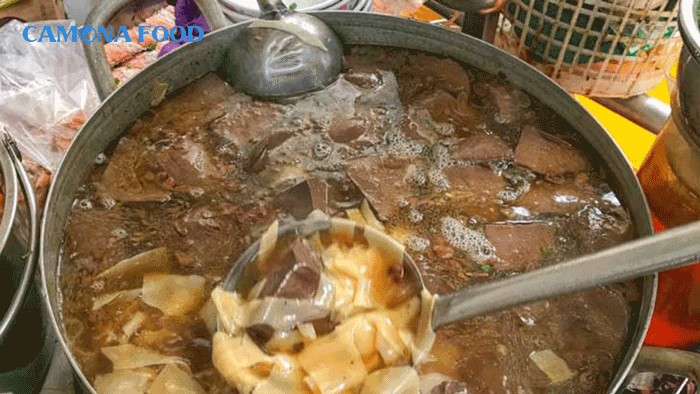 Nồi nước dùng đang ninh xương và tôm khô, tạo vị ngọt thanh cho cách nấu món ngon dễ làm.