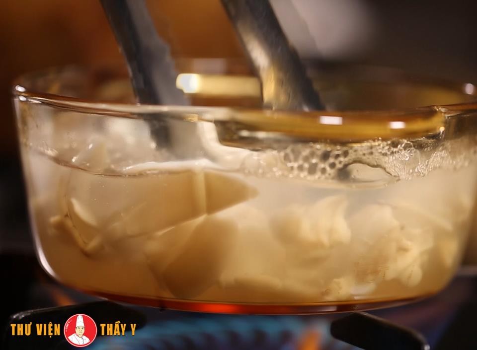 Mực tươi đang được luộc trong nồi, đảm bảo chín tới để có món hủ tiếu ngon và hấp dẫn.