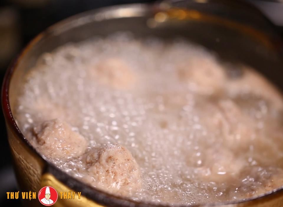 Những viên giò sống đang được chần trong nước sôi, đảm bảo độ dai ngon cho tô hủ tiếu.