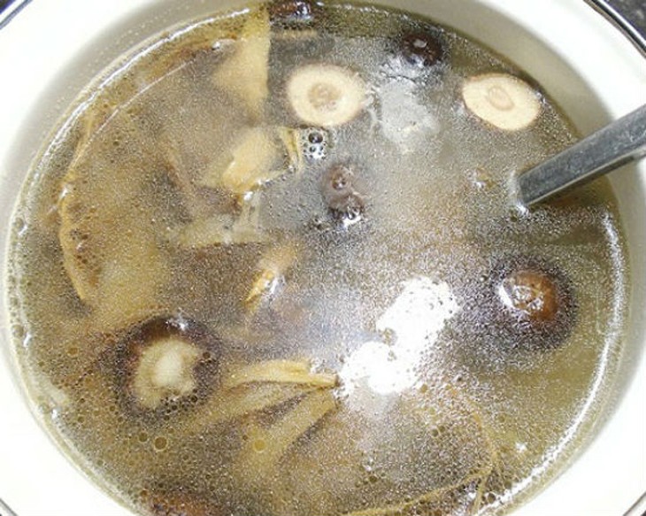 Xào măng và nấm hương trong chảo để chuẩn bị cho nước dùng miến vịt