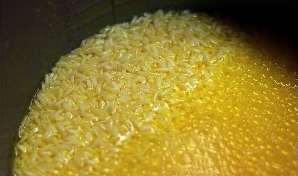 Nồi gà đang luộc với hành tím và nghệ tươi, tạo nước dùng đậm đà cho cách nấu cơm gà Thượng Hải
