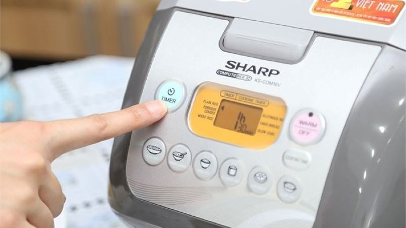 Người dùng đang thao tác trên nồi cơm điện tử Sharp