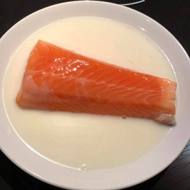 Nồi cháo gạo đang được nấu nhừ, chuẩn bị cho món ăn dặm cá hồi cà rốt của bé 9 tháng