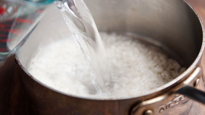 Gạo đang được vo sạch để nấu cháo, chuẩn bị cho món ăn dặm thịt bò cà rốt của bé 9 tháng