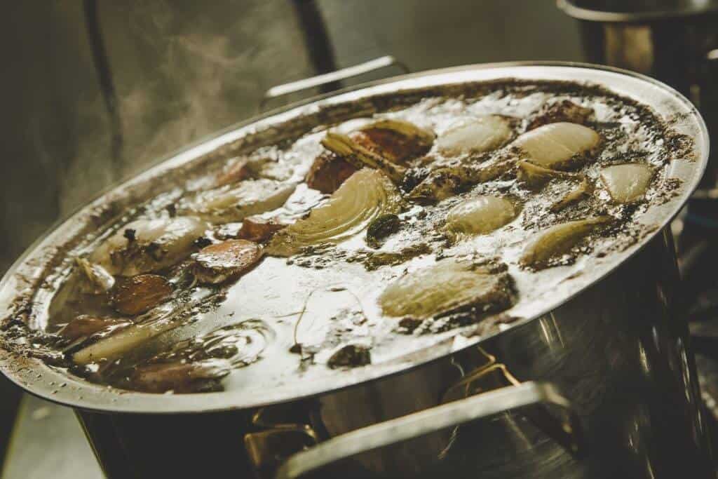 Nồi nước dùng lẩu bò Ba Toa đang sôi liu riu trên bếp, chuẩn bị cho bữa ăn thịnh soạn