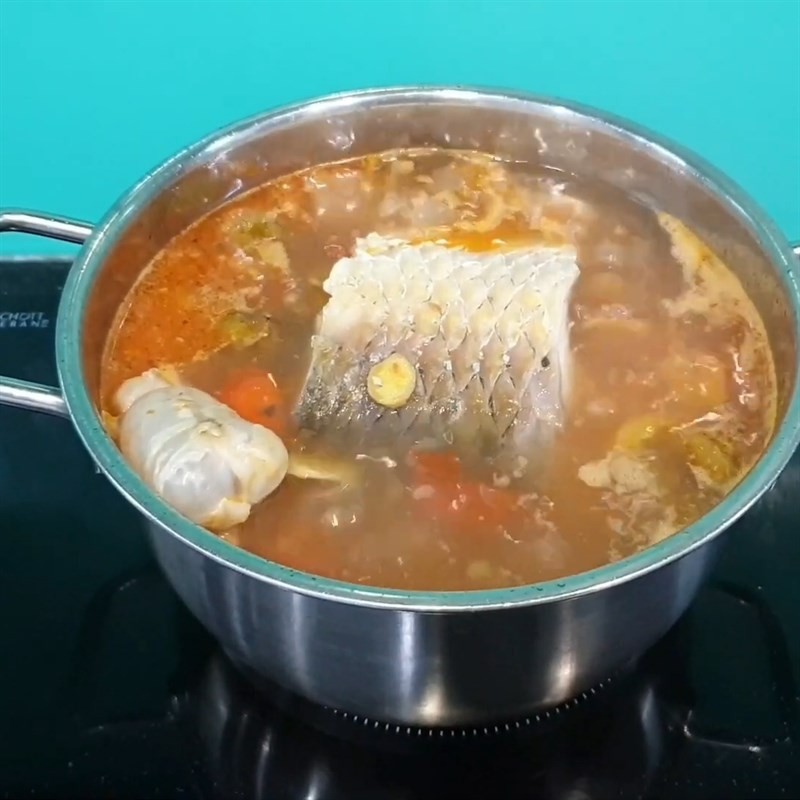 Nồi canh cá trắm nấu sấu đang sôi nhẹ trên bếp