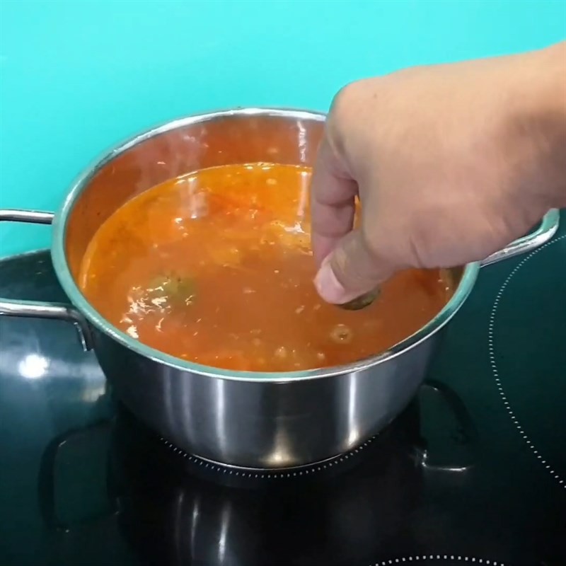 Cho cá trắm vào nồi canh đang sôi, chuẩn bị món canh ngon