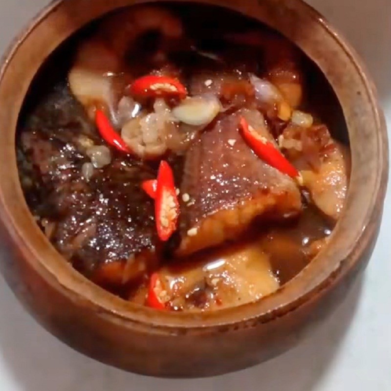 Nồi cá lóc kho me đang sôi nhẹ, nước sốt bắt đầu keo lại
