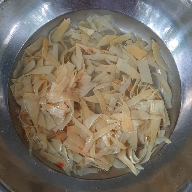 Nồi thịt ba chỉ kho măng tươi đang được đun sôi trên bếp với lửa nhỏ, nước kho dần cạn và sánh lại