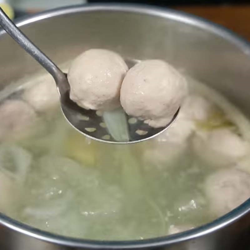 Viên mọc đang được luộc chín trong nồi nước dùng gà thơm lừng
