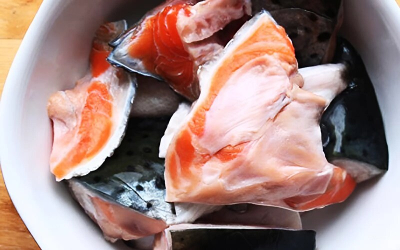 Đầu cá hồi tươi ngon được làm sạch kỹ lưỡng trước khi nấu canh ngót