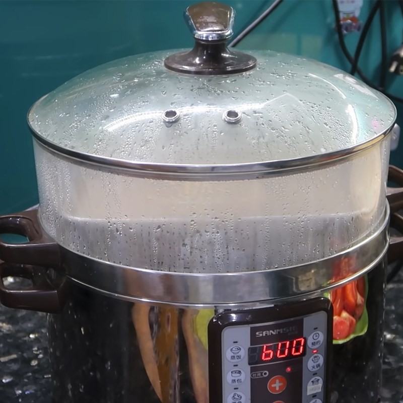 Phết gạch cua lên bề mặt chả riêu đã hấp để tạo màu sắc hấp dẫn