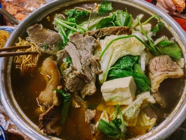 Nồi nước dùng lẩu bò khoai môn đang sôi nhẹ, toả hương thơm