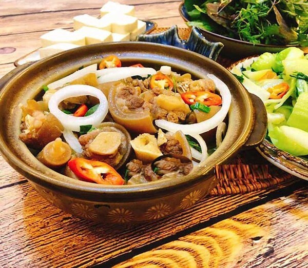 Bàn ăn thịnh soạn với nồi lẩu đuôi bò chua cay nóng hổi, mời gọi