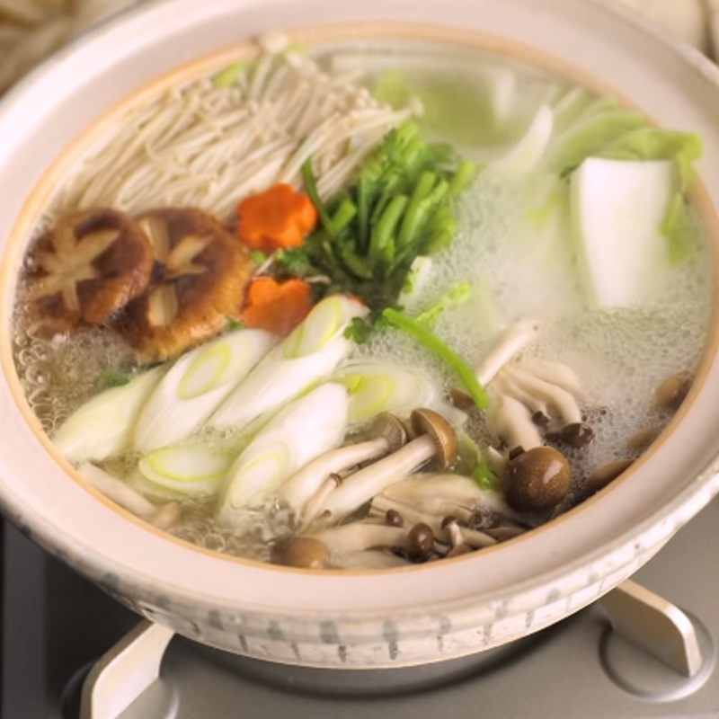 Thực khách đang nhúng từng lát thịt bò vào nồi lẩu shabu shabu sôi sùng sục