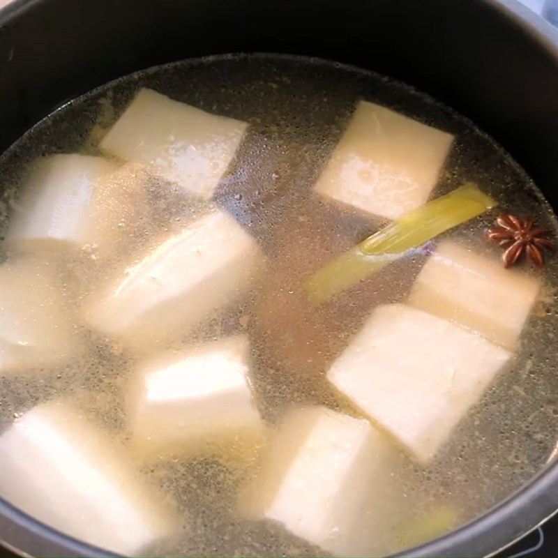 Đuôi bò và củ cải đang hầm trong nồi nước dùng