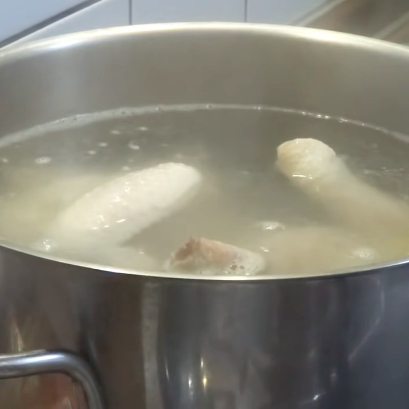Luộc gà trong nồi để làm món gà sa tế