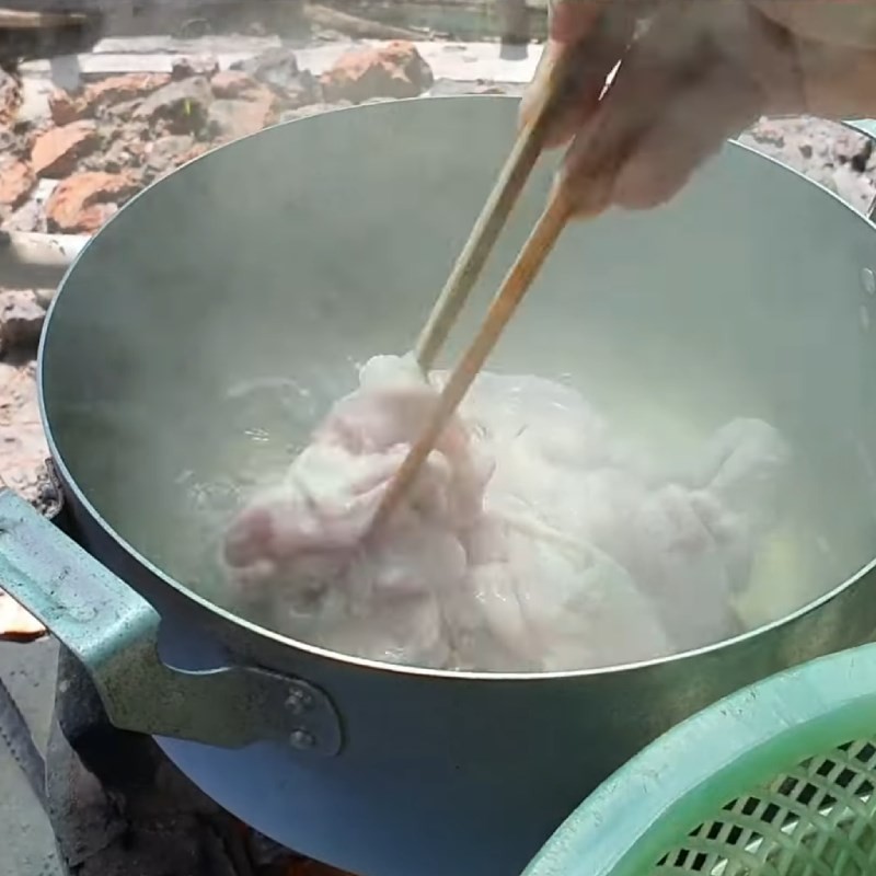Luộc lòng heo và tim heo trong nồi nước sôi cùng gừng và sả để loại bỏ mùi hôi và làm lòng mềm thơm