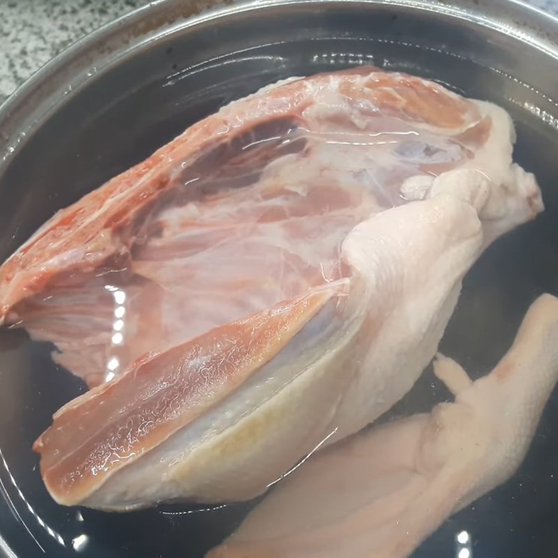 Luộc sơ ngan trong nồi nước sôi có thêm muối và rượu, vớt bọt kỹ để khử mùi hôi và làm sạch thịt ngan, bước quan trọng để có món bún ngan ngon
