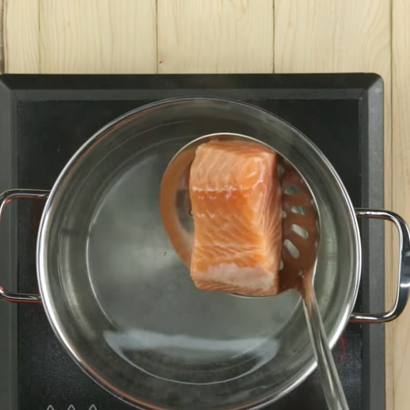 Luộc cá hồi để làm cháo cá hồi bí đỏ