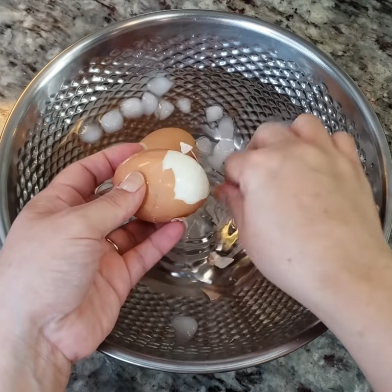 Cắt đôi trứng gà đã luộc, sẵn sàng cho món mì với tôm