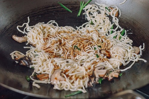 Rưới đều sốt gia vị lên mì xào chay để thấm đều hương vị