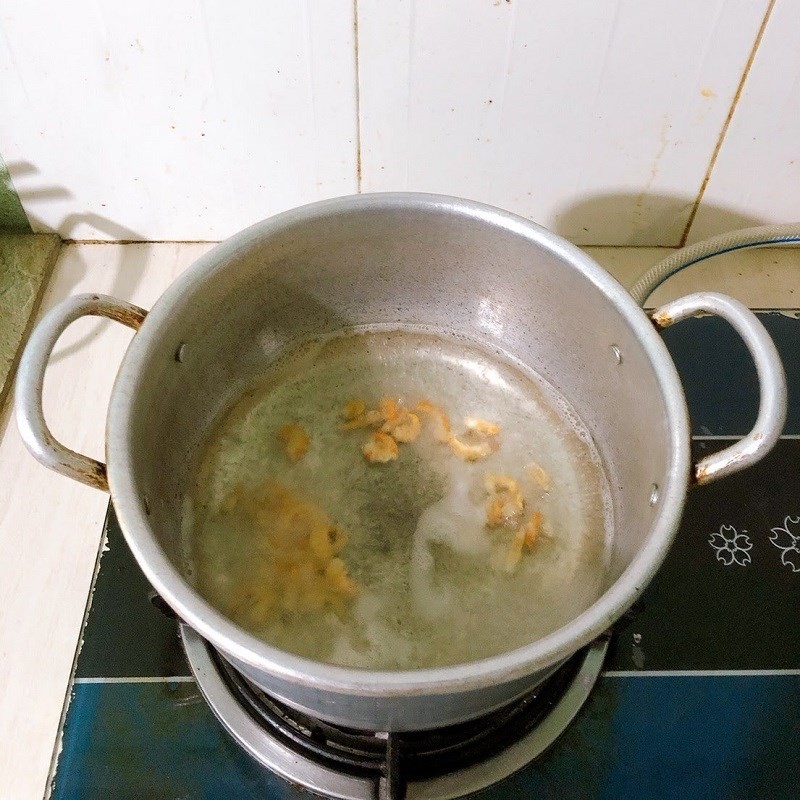Nêm nếm và thêm hành lá vào canh củ từ sườn heo trước khi tắt bếp