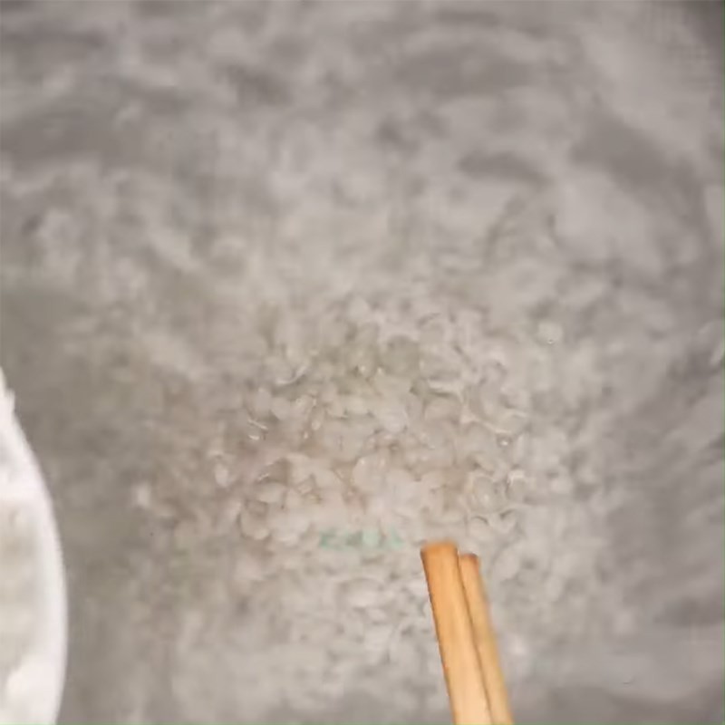 Gạo và đậu xanh đang được ninh nhừ trong nồi, tạo nền cháo mịn và sánh cho cách nấu cháo gà hạt sen.