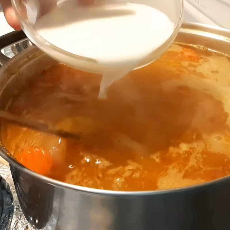Cho sợi bánh canh và thịt cua xào vào nồi nước dùng