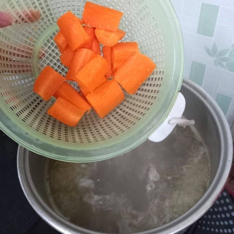 Nồi nước dùng xương heo và cà rốt đang sôi, chuẩn bị cho công đoạn nấu bánh bột lọc